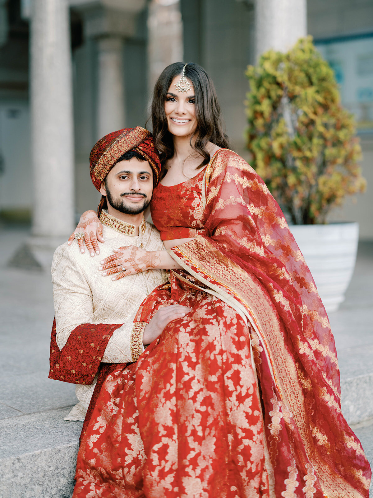 Bride sits on groom for a portrait