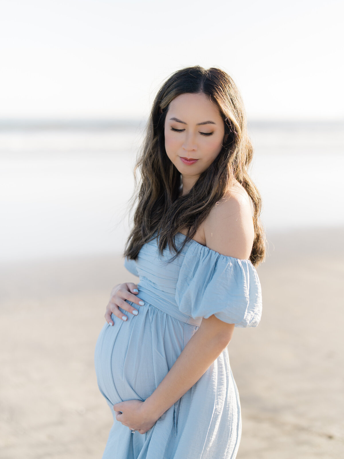 Beach maternity session of beautiful mom in blue dress
