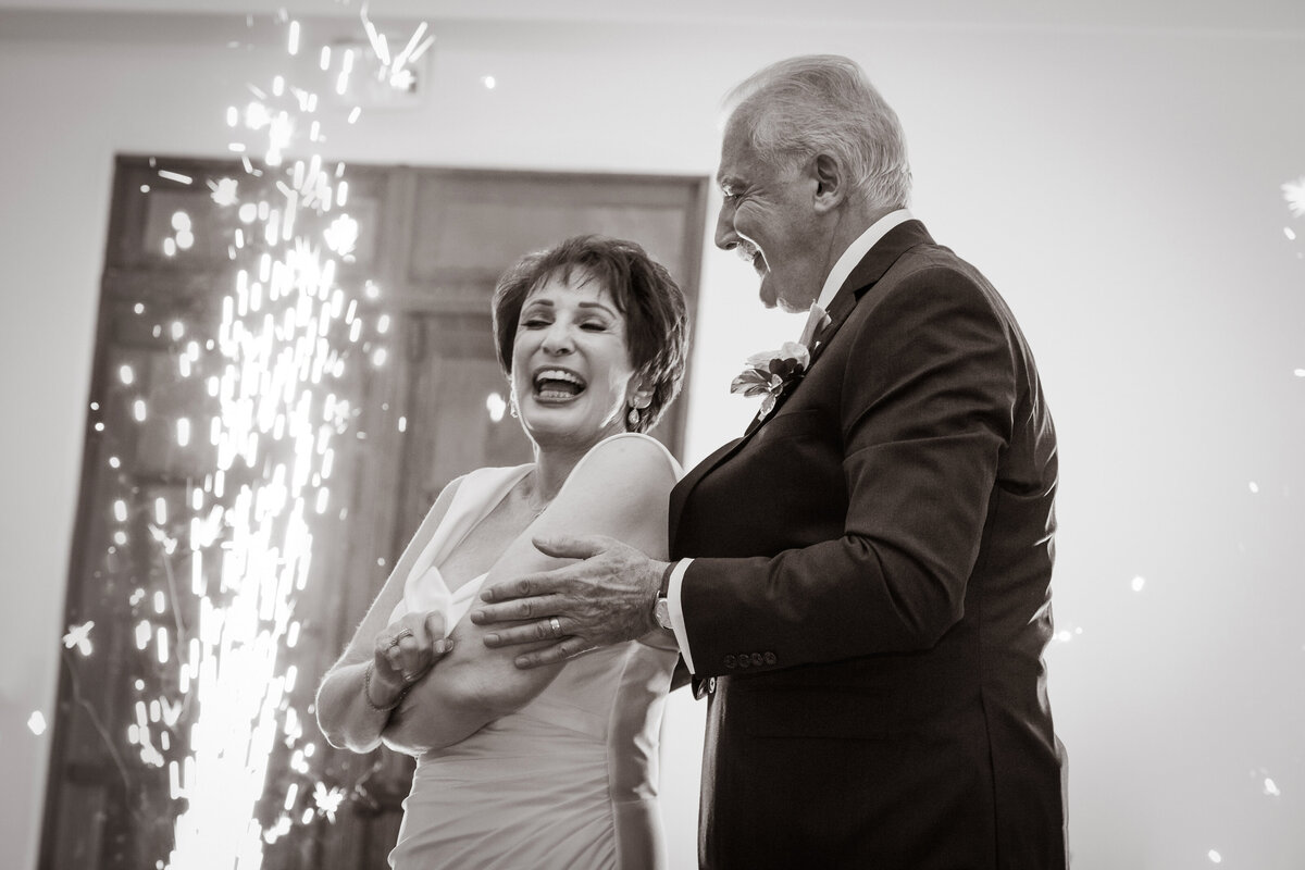 Bride and groom smile while dancing at their wedding reception