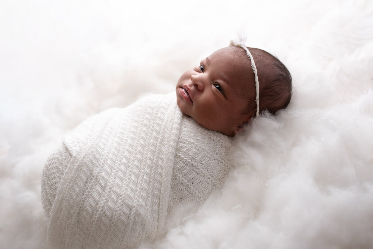 Wrapped newborn in white themed photo session
