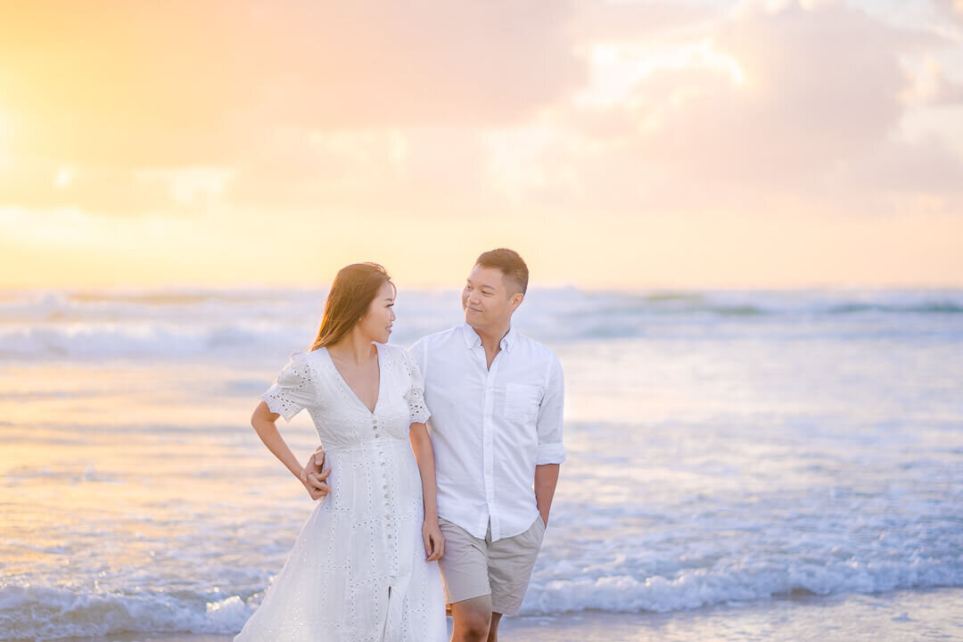 couple having fun on the beach at their engagement session in gold coast the spit