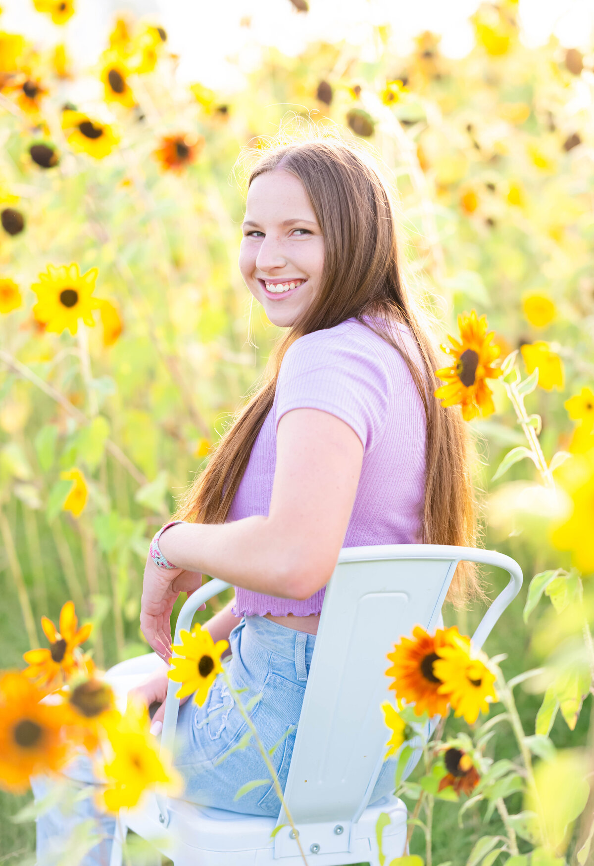 high school senior girl sitting sunflower field