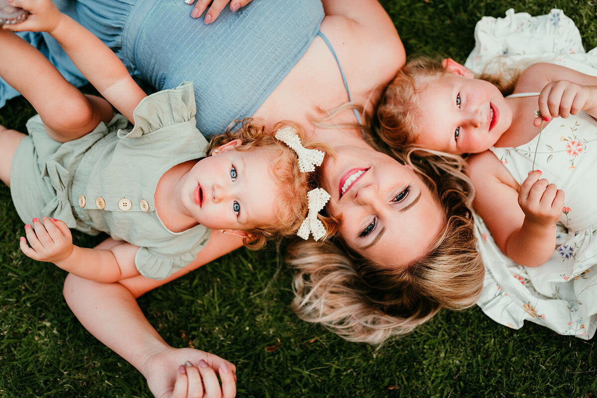 mother-and-daughters-laying-in-grass-on-summer-day