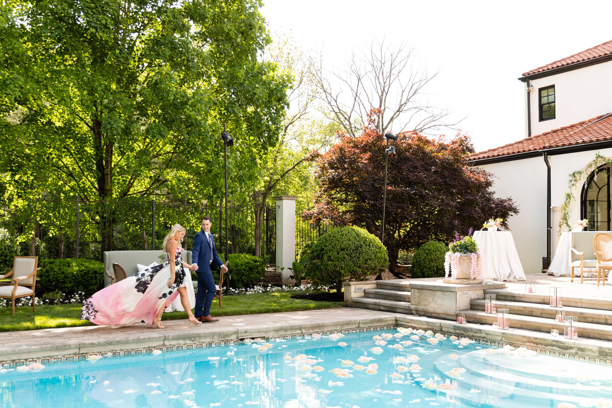 Bridgerton inspired engagement party at a private home in Nashville, TN with pastel candles and flowers floating in the pool.