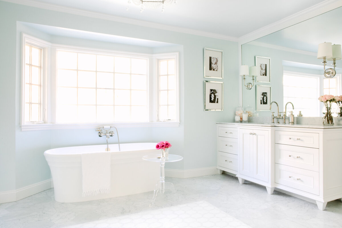 Master bathroom with light blue walls, Carrara marble hexagon floors, white vanities, free standing Victoria and Albert Tub, and Ann Sacks tile rug detail.