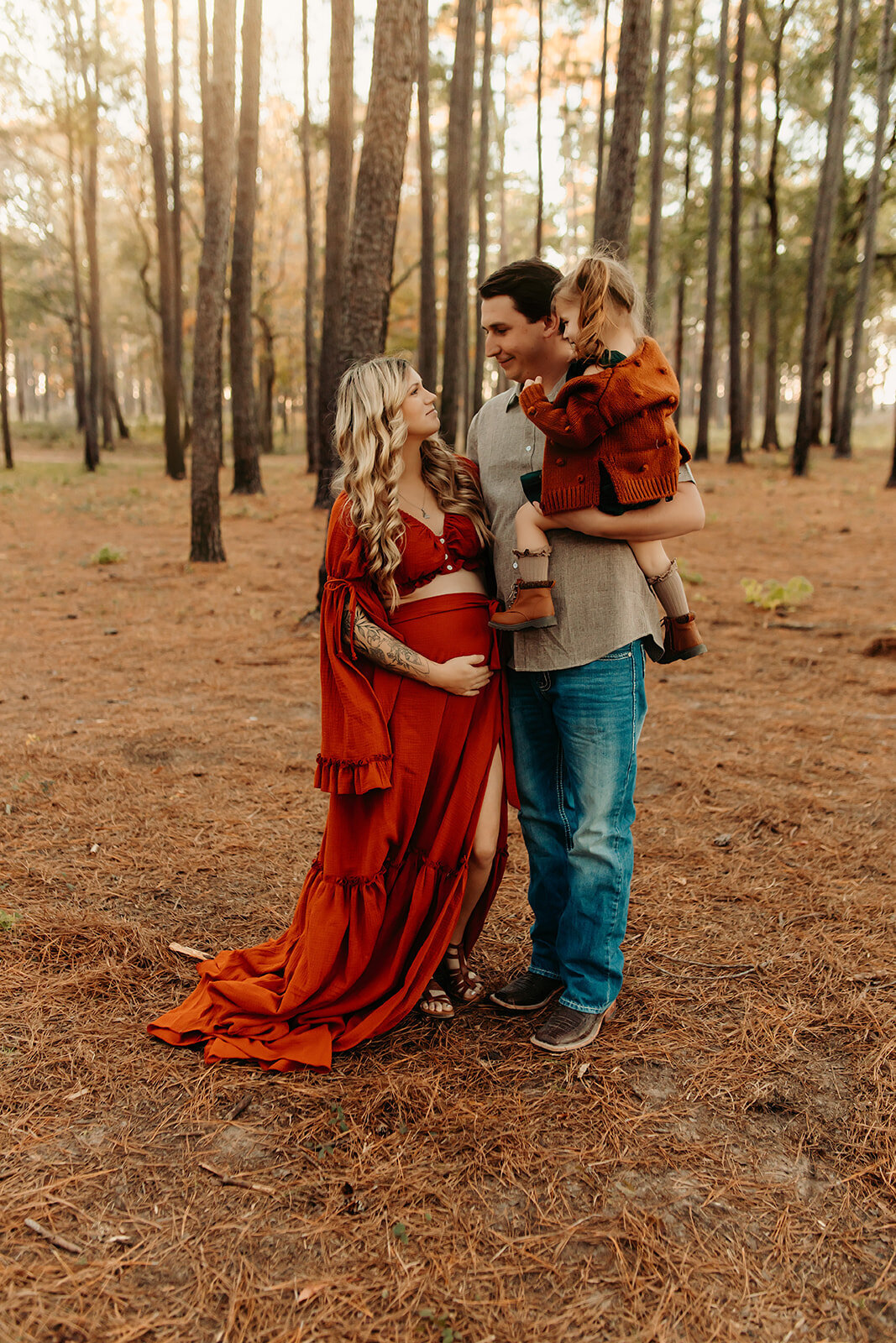 Family maternity session in The Woodlands TX—parents with young child outdoors