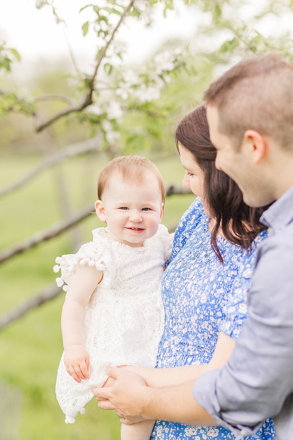 parents hold daughter. during Family photo session with Sara Sniderman Photography in Natick Massachusetts