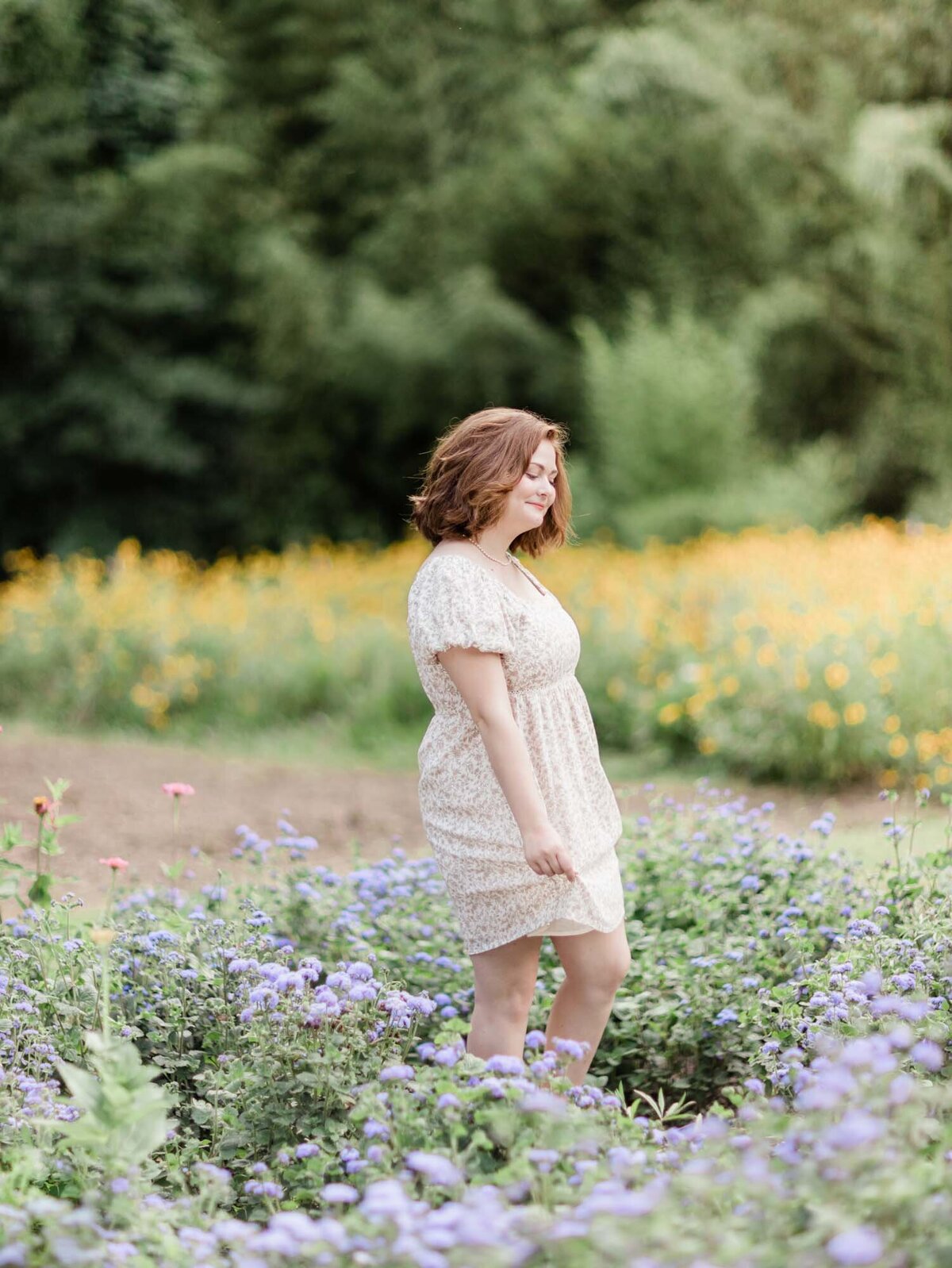 Senior portrait of a girl dancing in a field of flowers.