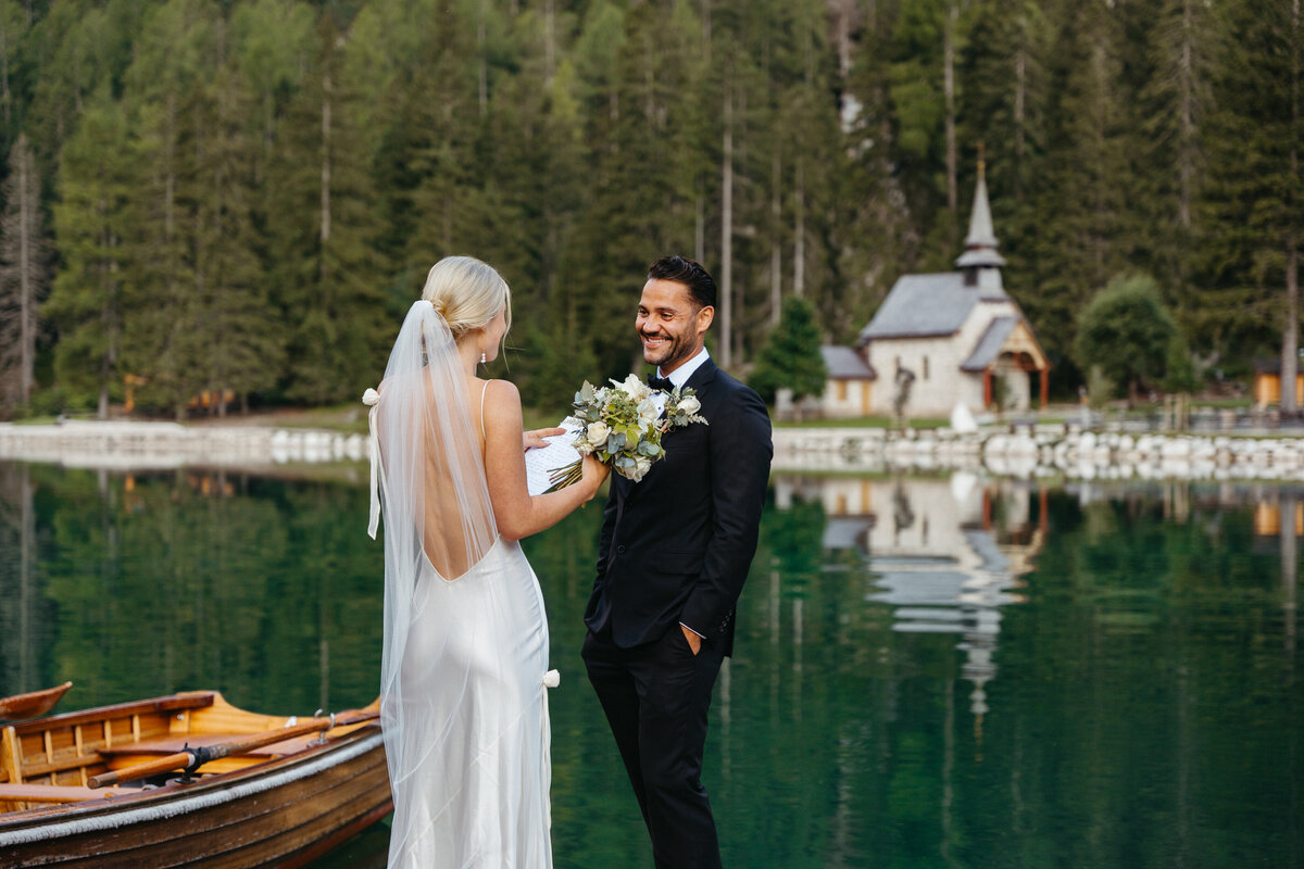 Bride and groom smiling while exchanging vows on dock
