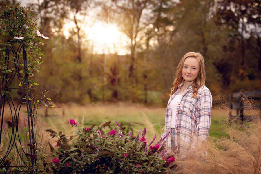 flowers and sunset light with red headed senior girl