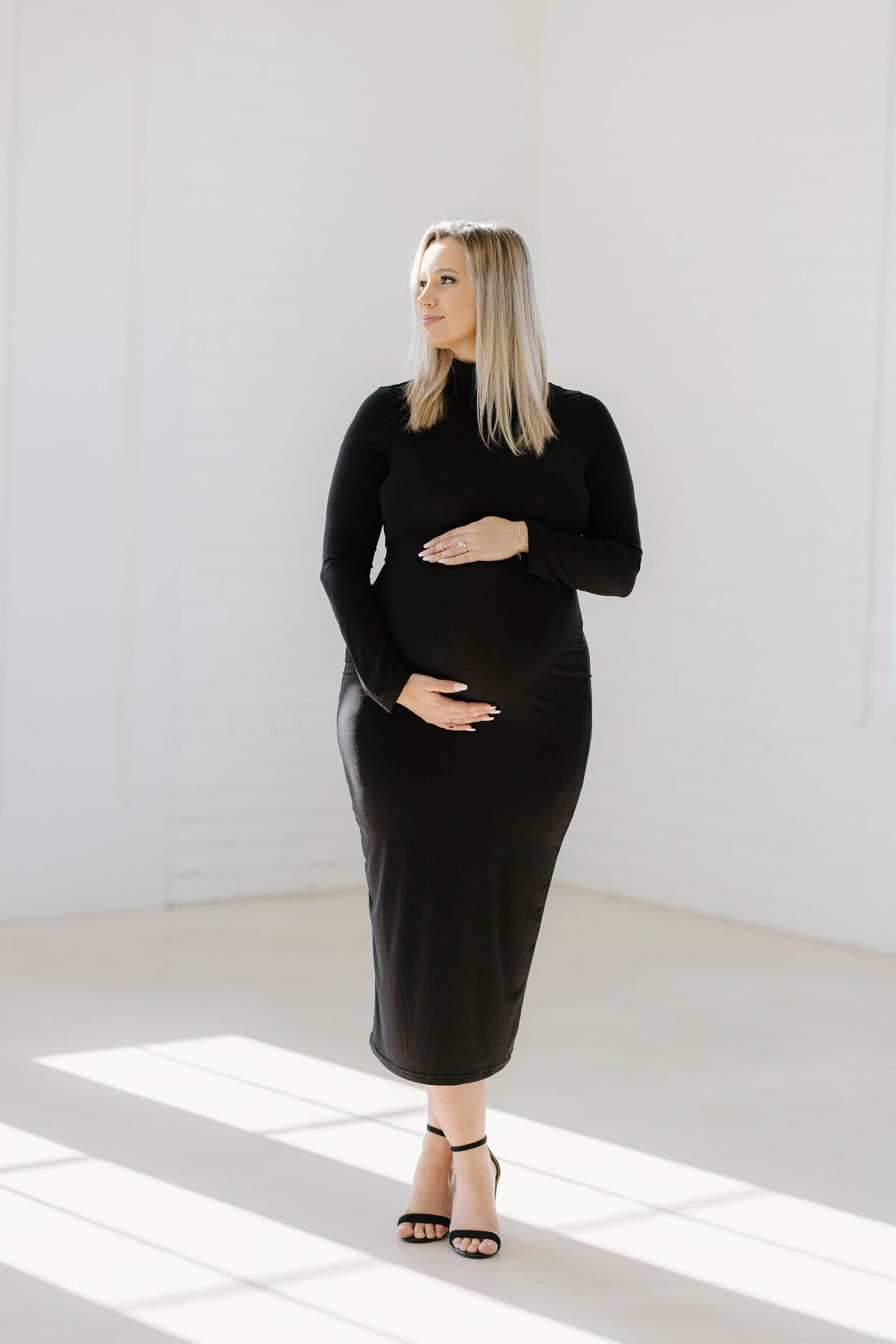 Fine art maternity portrait of mommy to be in long elegant black dress