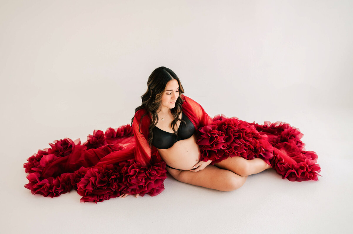 maternity picture in Springfield MO of pregnant mom sitting on floor with red robe
