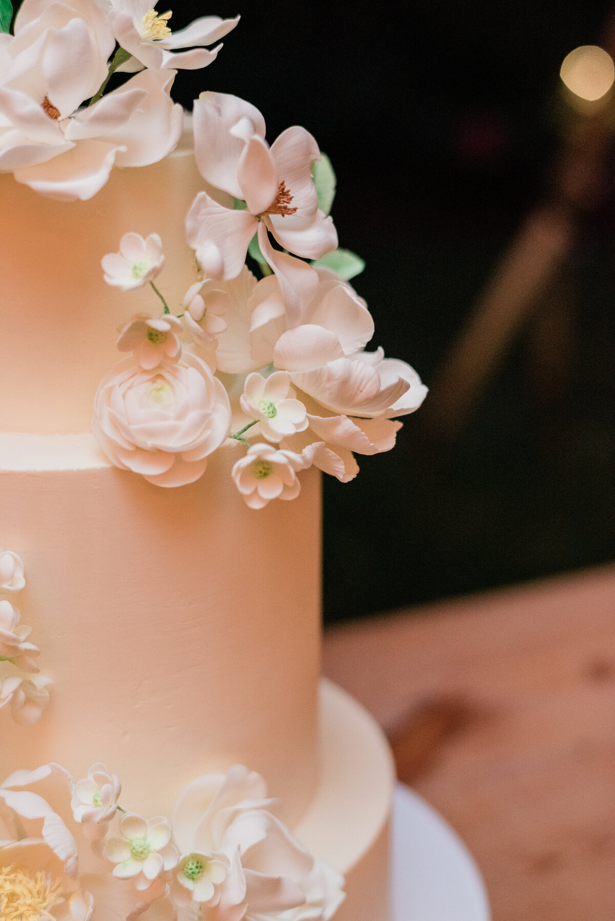Details of a white and peach floral wedding cake 