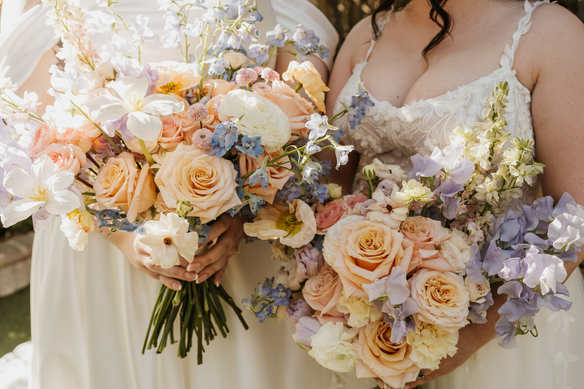 Two colorful bouquets of flowers behind held 