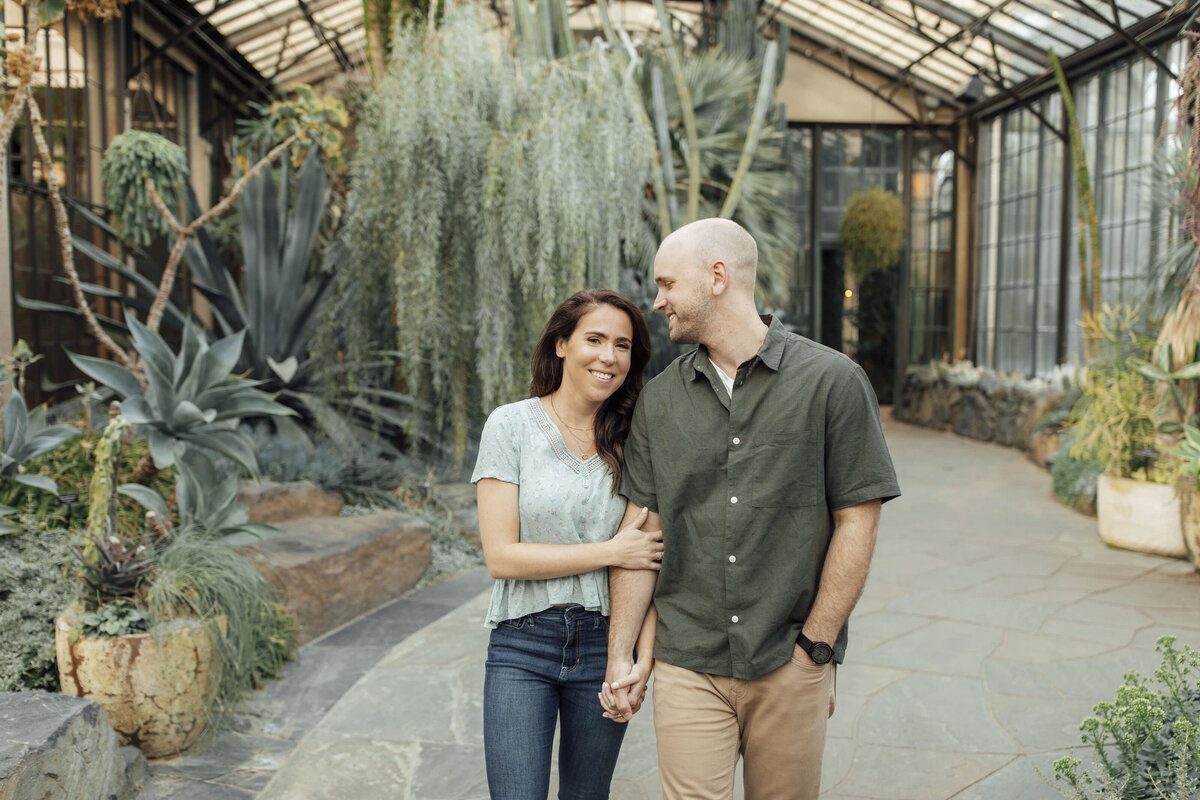 Couple by succulents in greenhouse during engagement session at Longwood Gardens in Kennett Square Pennsylvania