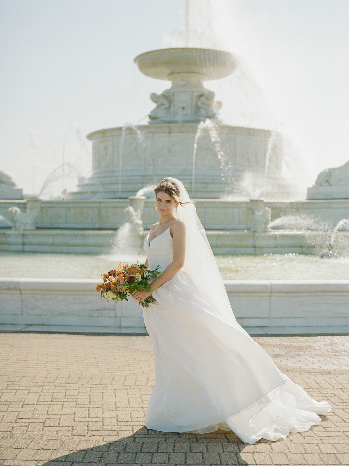 a beautiful bride stands near Belle Isle Fountain, Detroit