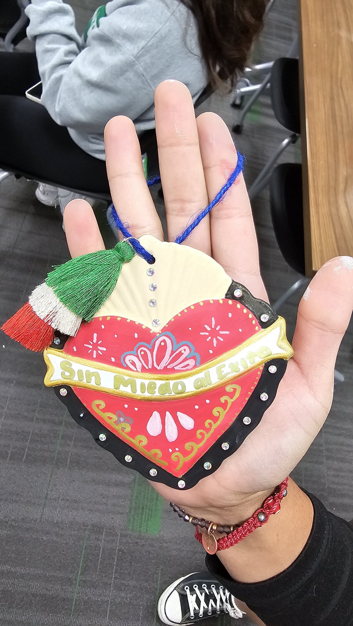 The artistic triumph as a workshop participant proudly presents their final masterpiece—a colorful heart adorned with an inspirational phrase. Tthe materials that brought this creation to life at Soleil Vida Studio.