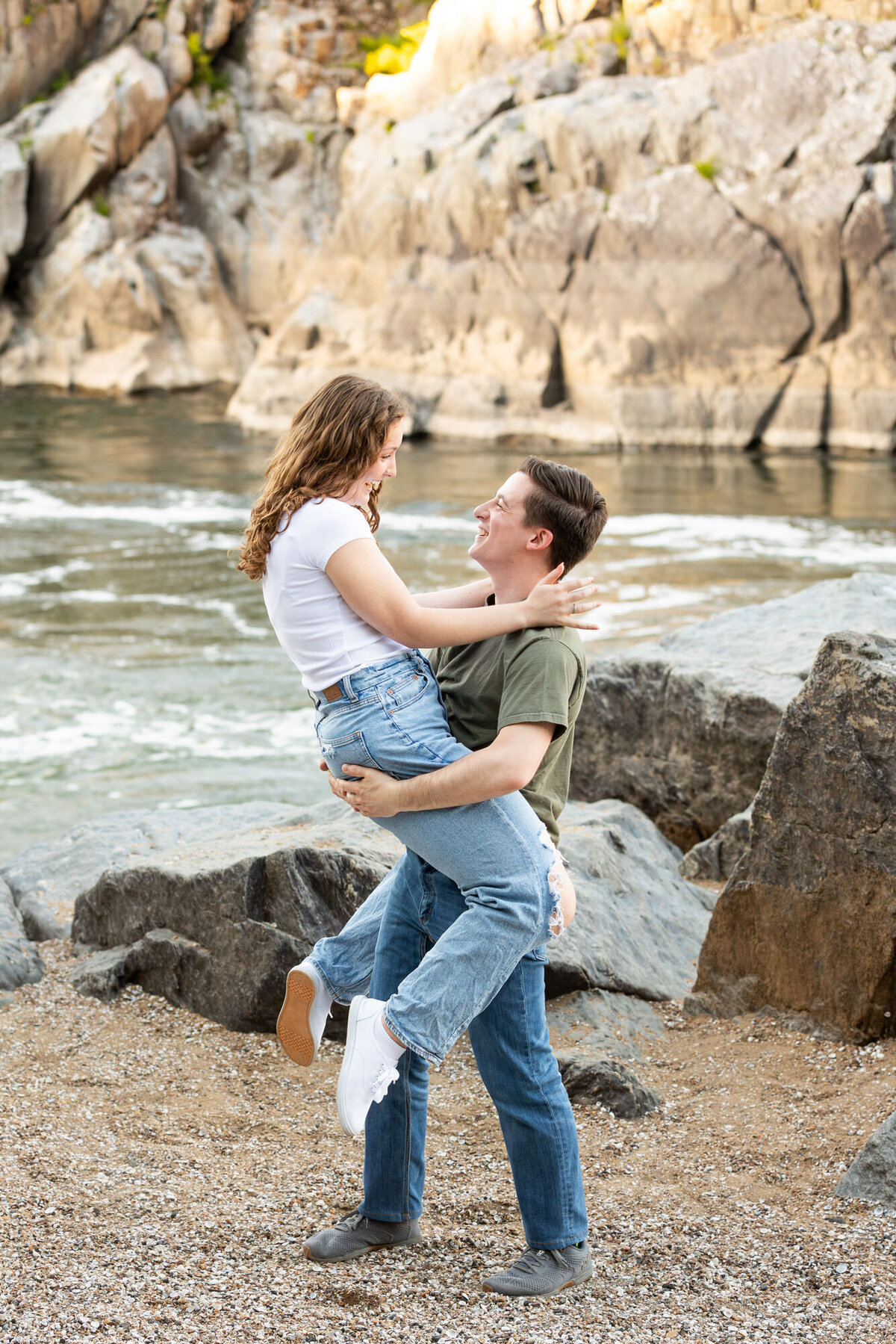 Engaged Couple Great Falls Virginia jumping into her boyfriends arms while laughing