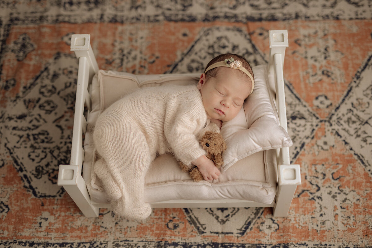 Newborn girl on white bed prop at Pittsburgh photography studio