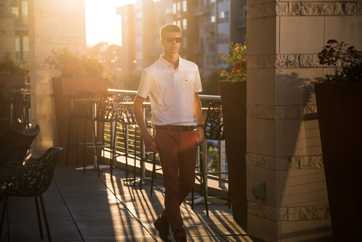Stylish outdoor portrait of a well-dressed man walking along a promenade with editorial flair.