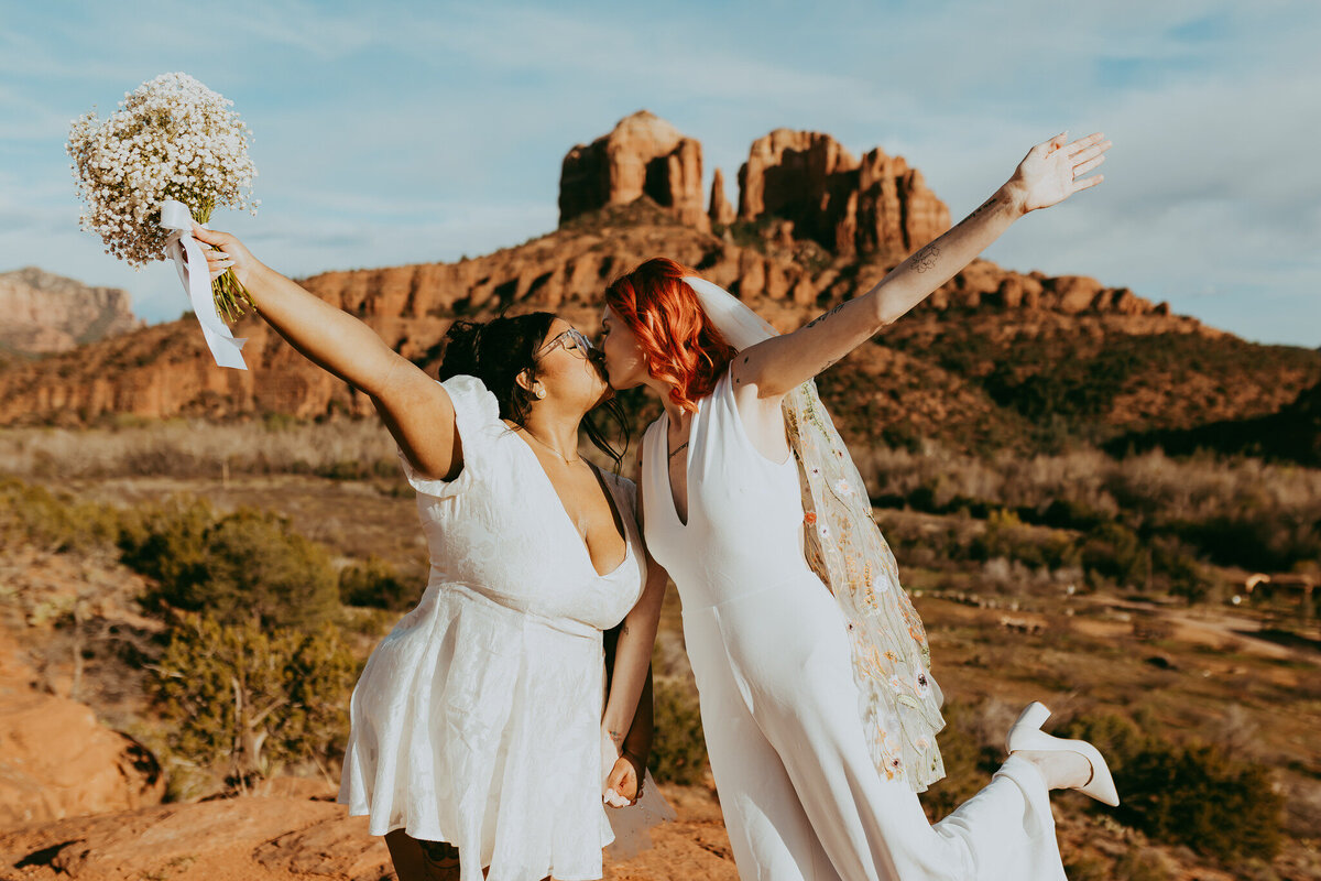 two brides kiss with cathedral rock in backdrop