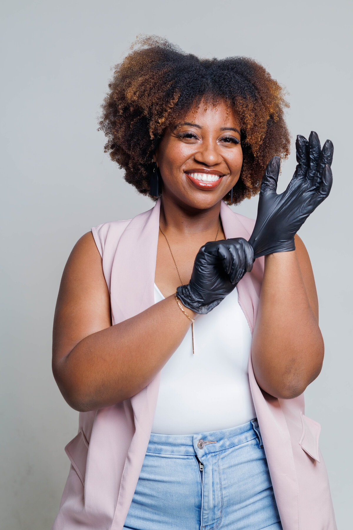Jazzy putting on black gloves before starting a service at Jazzy's Glam Bar in Tampa, FL