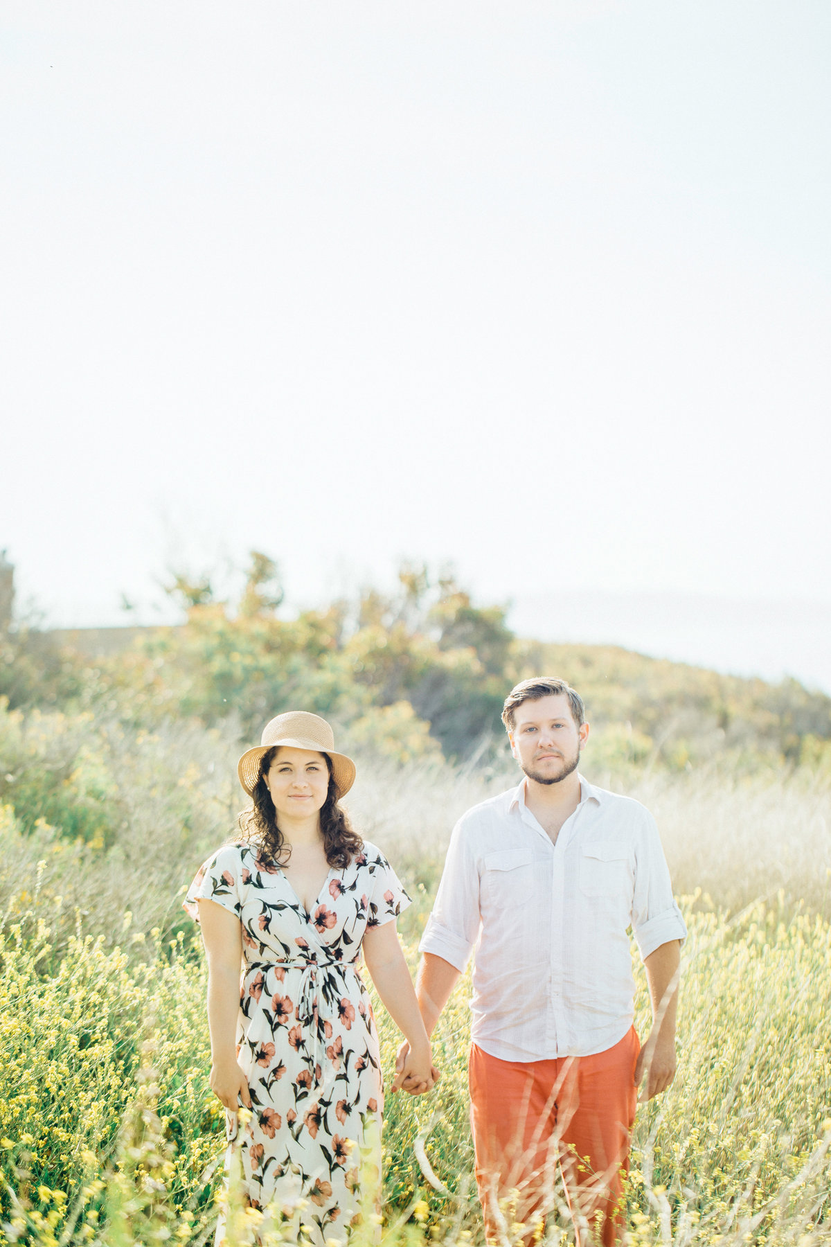 Engagement Photograph Of  Man And Woman Holding Hands In The Middle Of Meadow Los Angeles