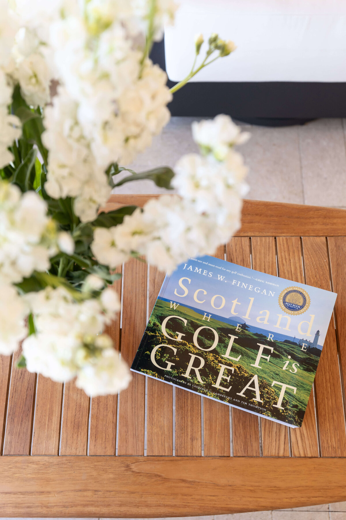 coffee table book with white flowers on teak table (1)