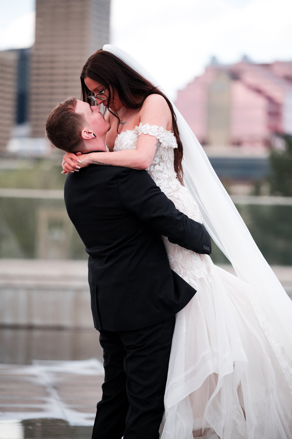 man picks up his bride and gives her a kiss