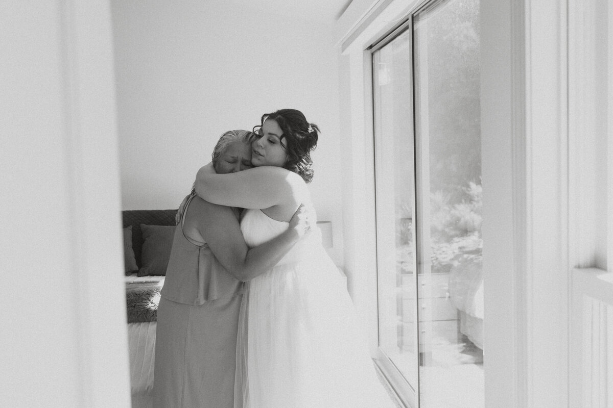 A person in a wedding dress hugging someone. 