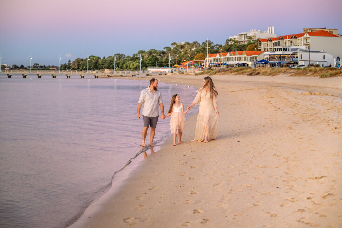 family strolls down the beach for family photos