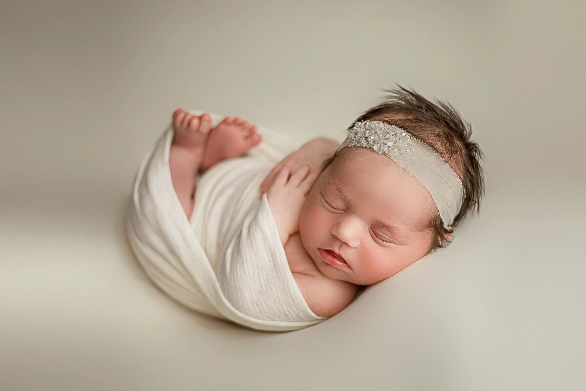 newborn-in-cream-wrap-on-beanbag