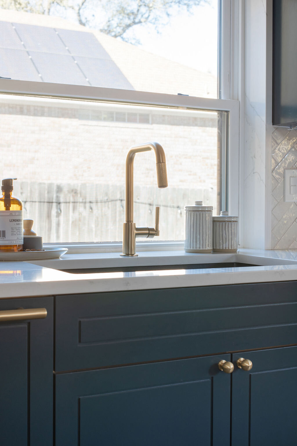 hello-home-austin-contemporary-navy-kitchen-remodel-brass-faucet-zelliege-herringbone-backsplash-open-layout-10