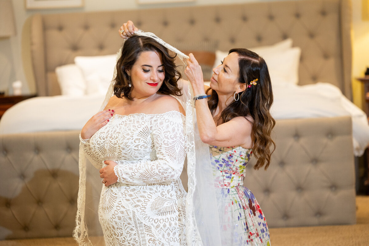 A person helping a bride with her veil