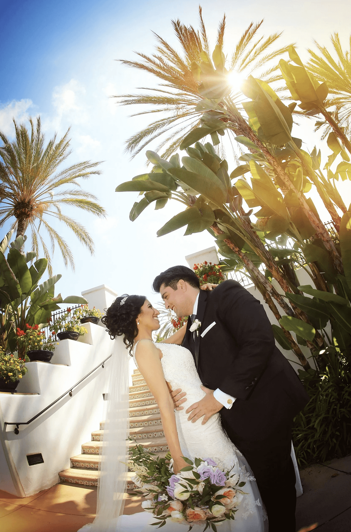 omni-la-costa-palm-lined-staircase-wedding-bride-groom-dip