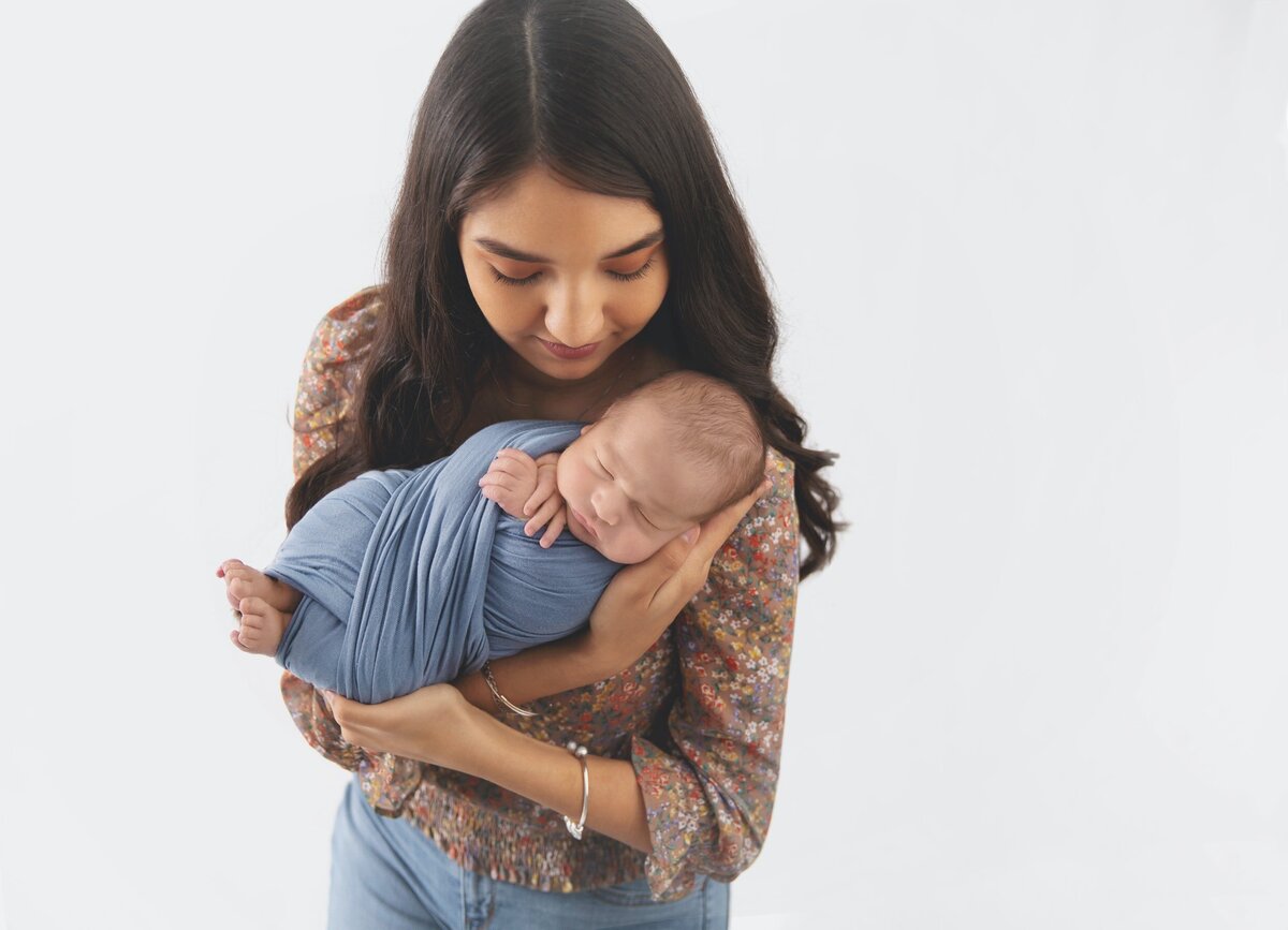 Mom holding swaddled newborn