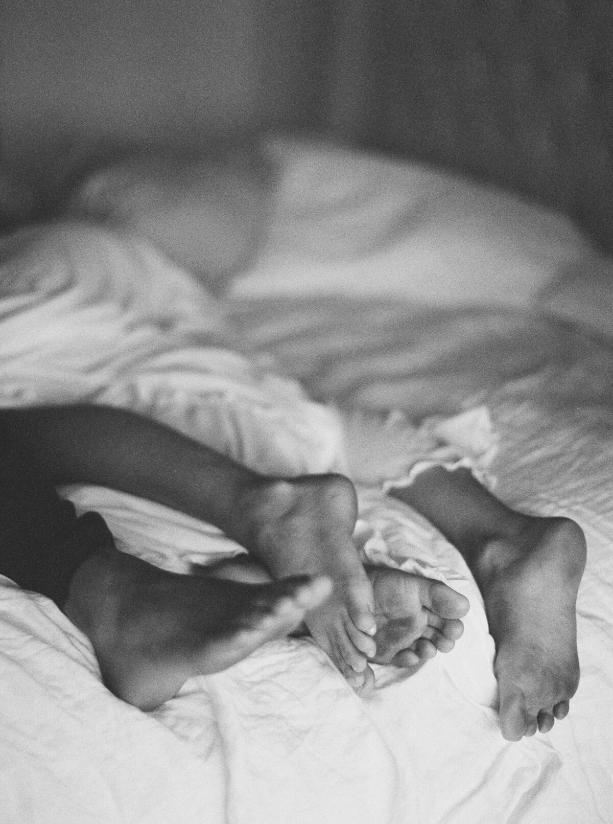 Black and white shot of couples feet in bed in Los Angeles