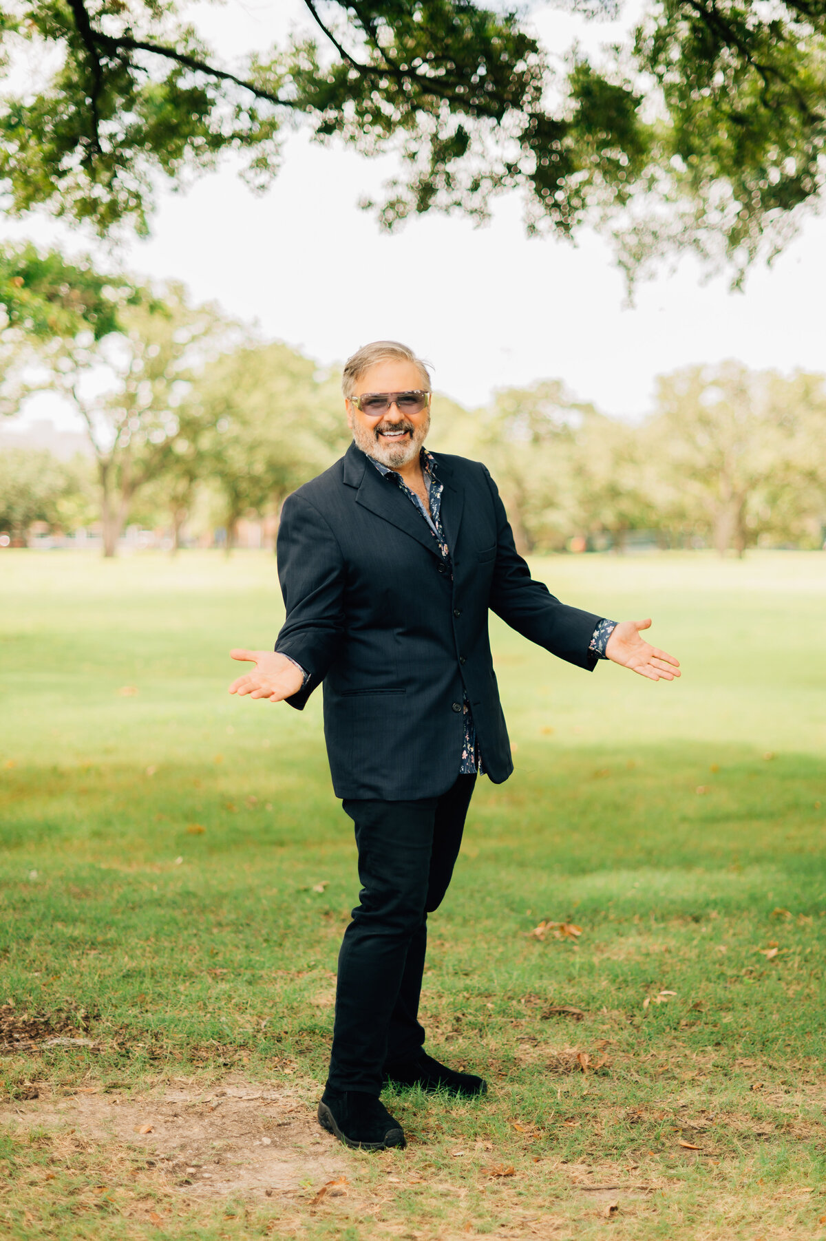 Ernie Manouse smiling outdoors in Houston park for branding photography