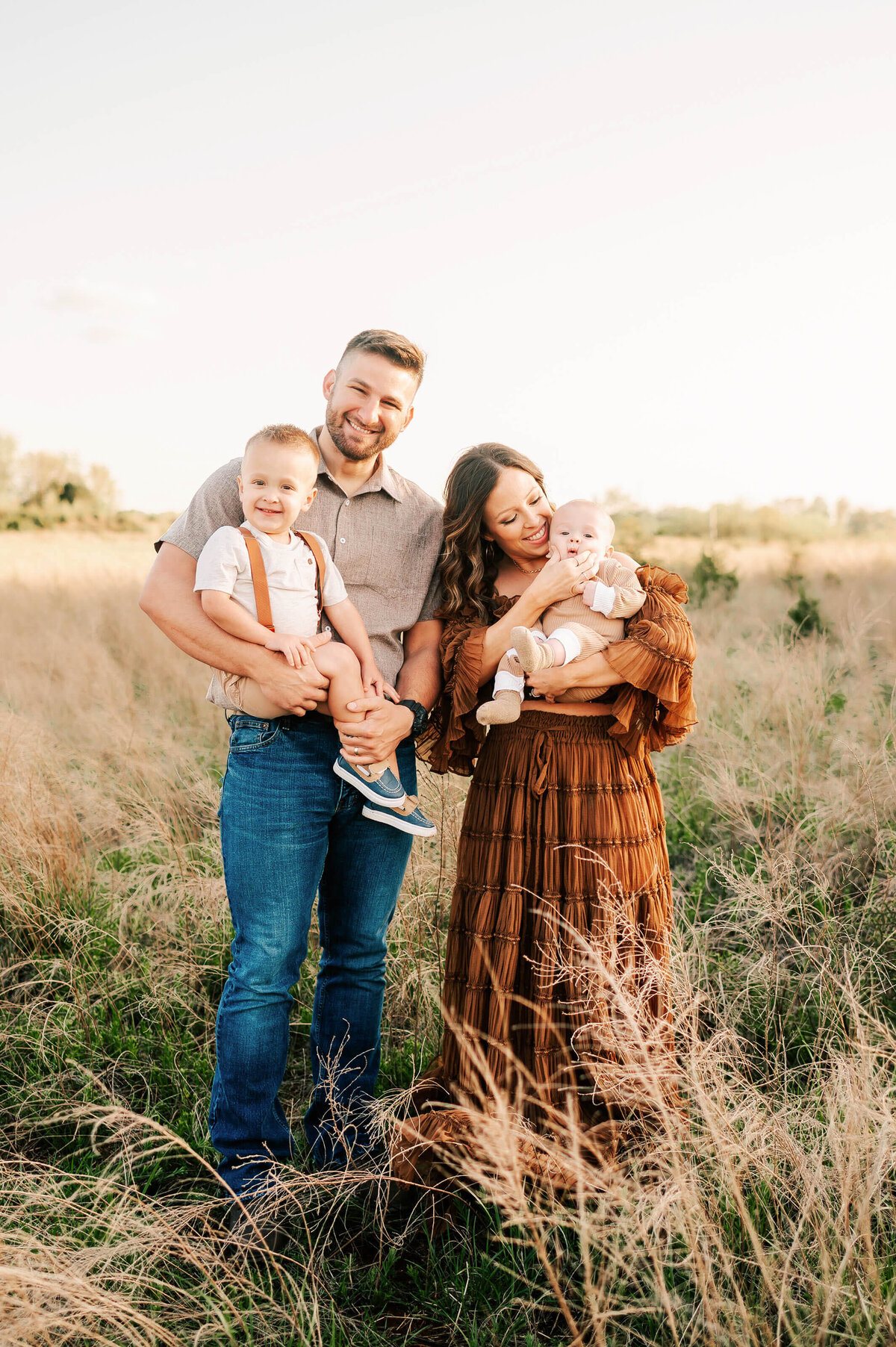 Springfield MO family photographer Jessica Kennedy of The XO Photography captures family cuddling in a field at sunset