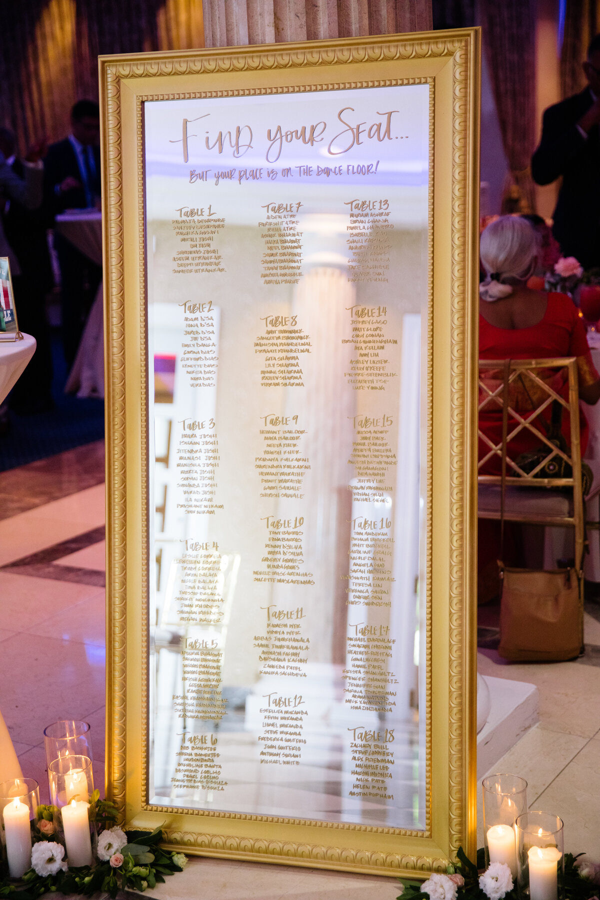 wedding mirror seating chart on a gold ornate framed mirror
