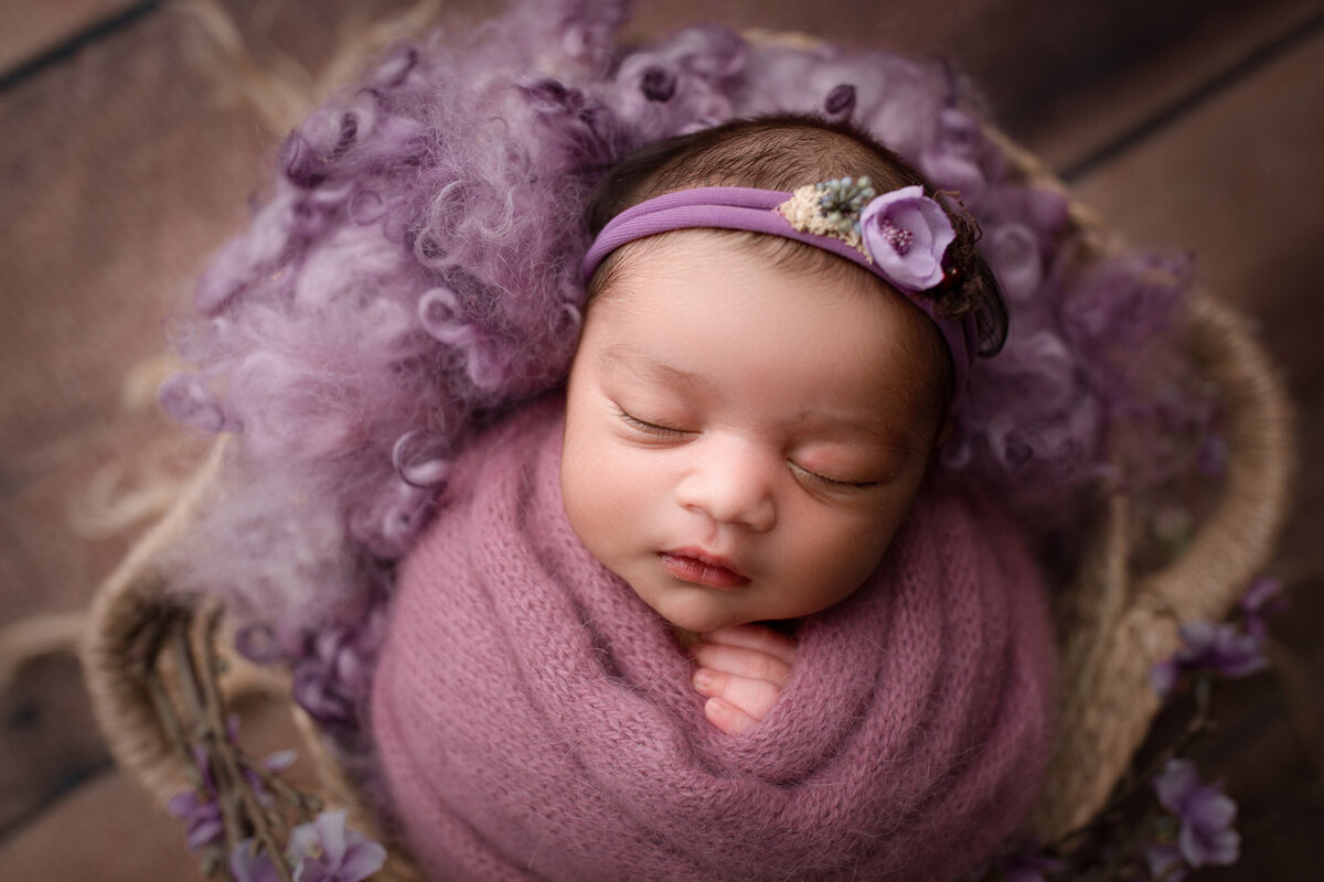 baby girl wrapped in purple with purple headband