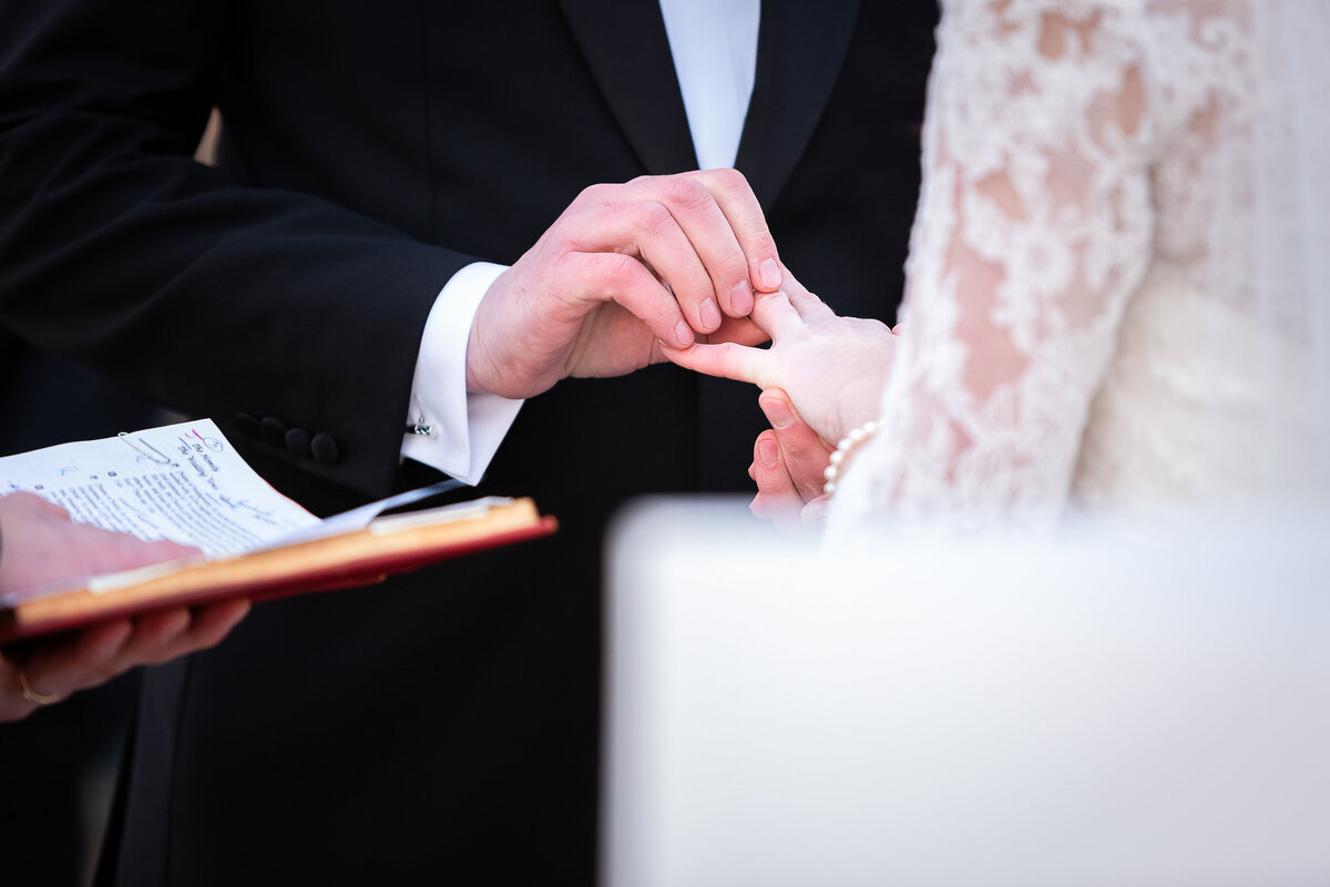 Groom Places Wedding Ring on Bride's Left Ring Finger