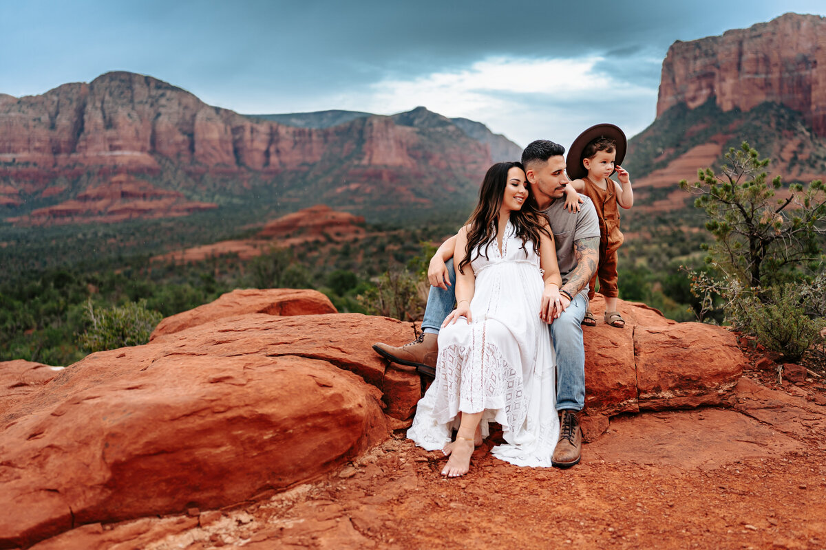 family sitting on a boulder in Sedona