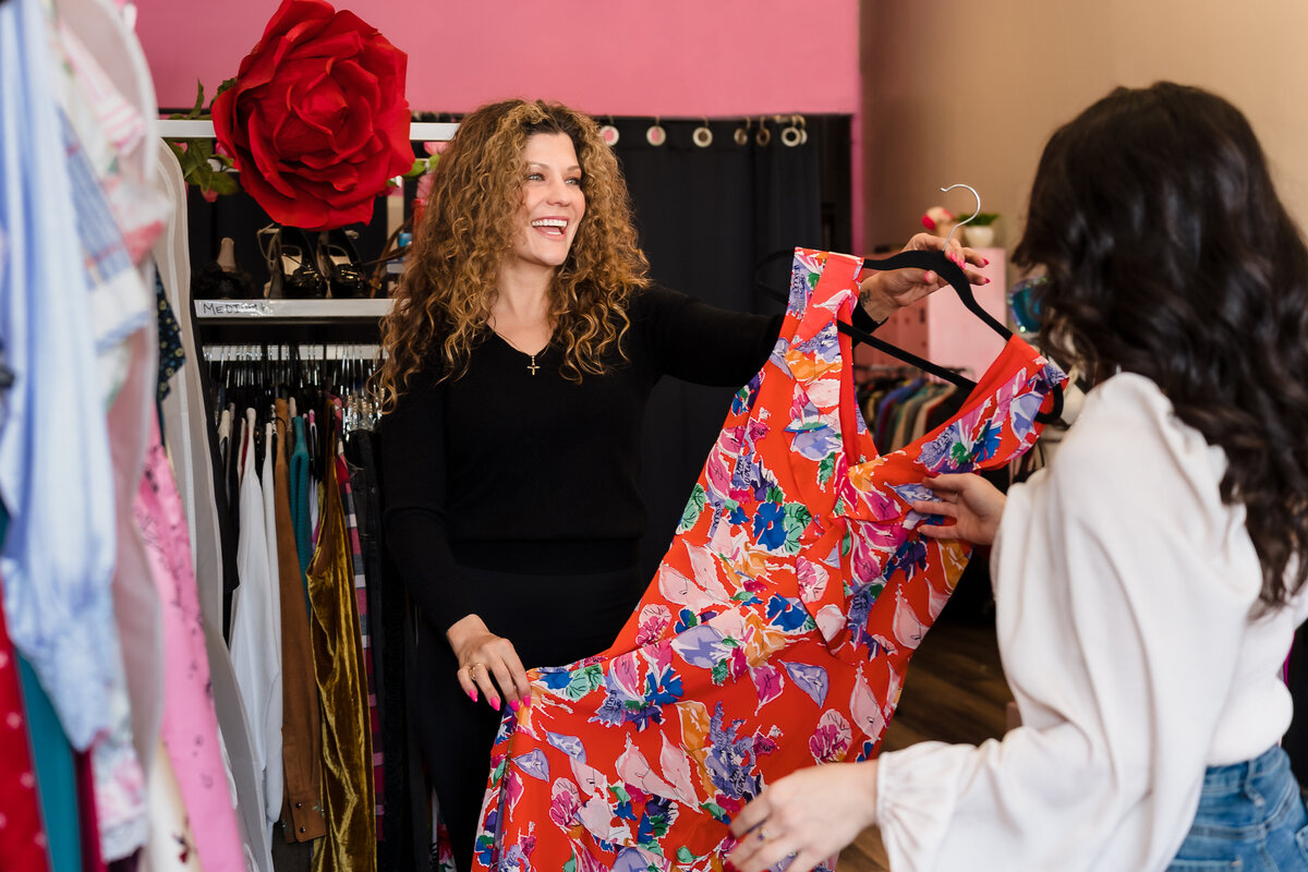 store owner showing a dress for a client