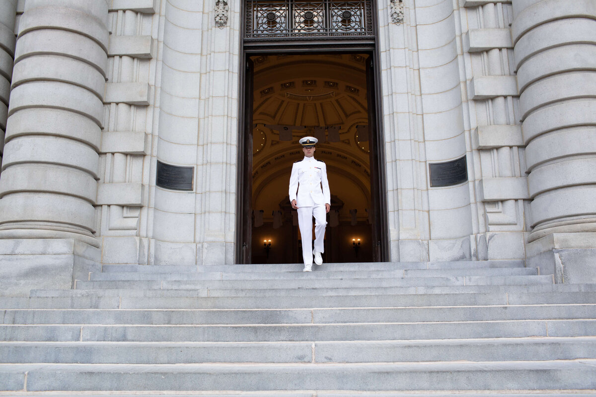 Senior Midshipman takes photos with Kelly Eskelsen on the steps of Naval Academy Bancroft Hall.