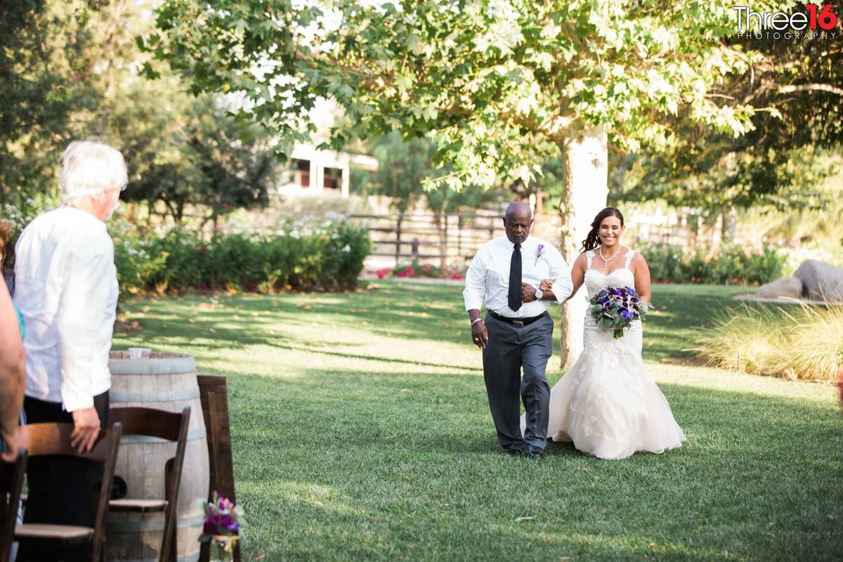 Bride being escorted down the aisle