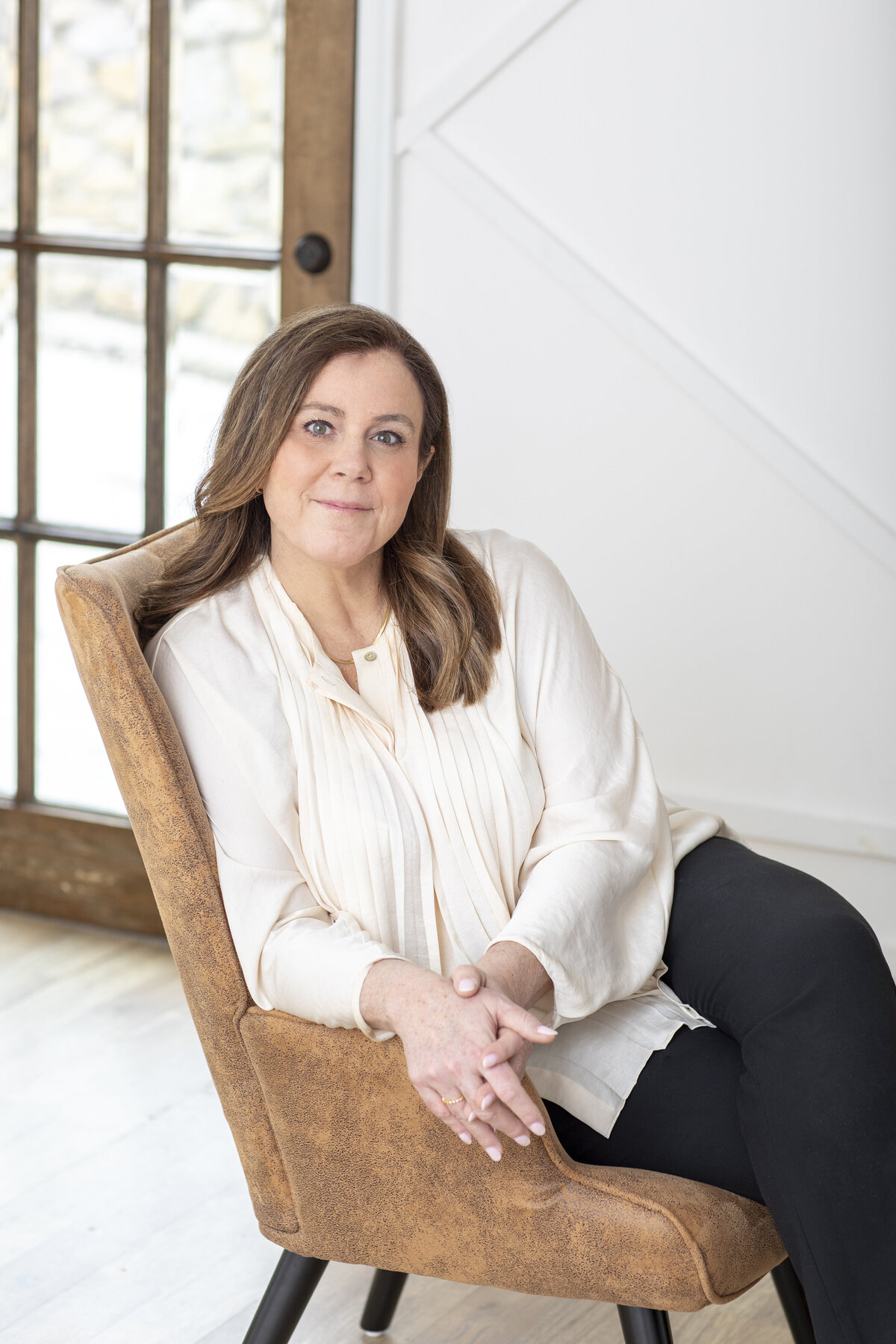 Modern portrait of a woman seated in a chair for a branding headshot