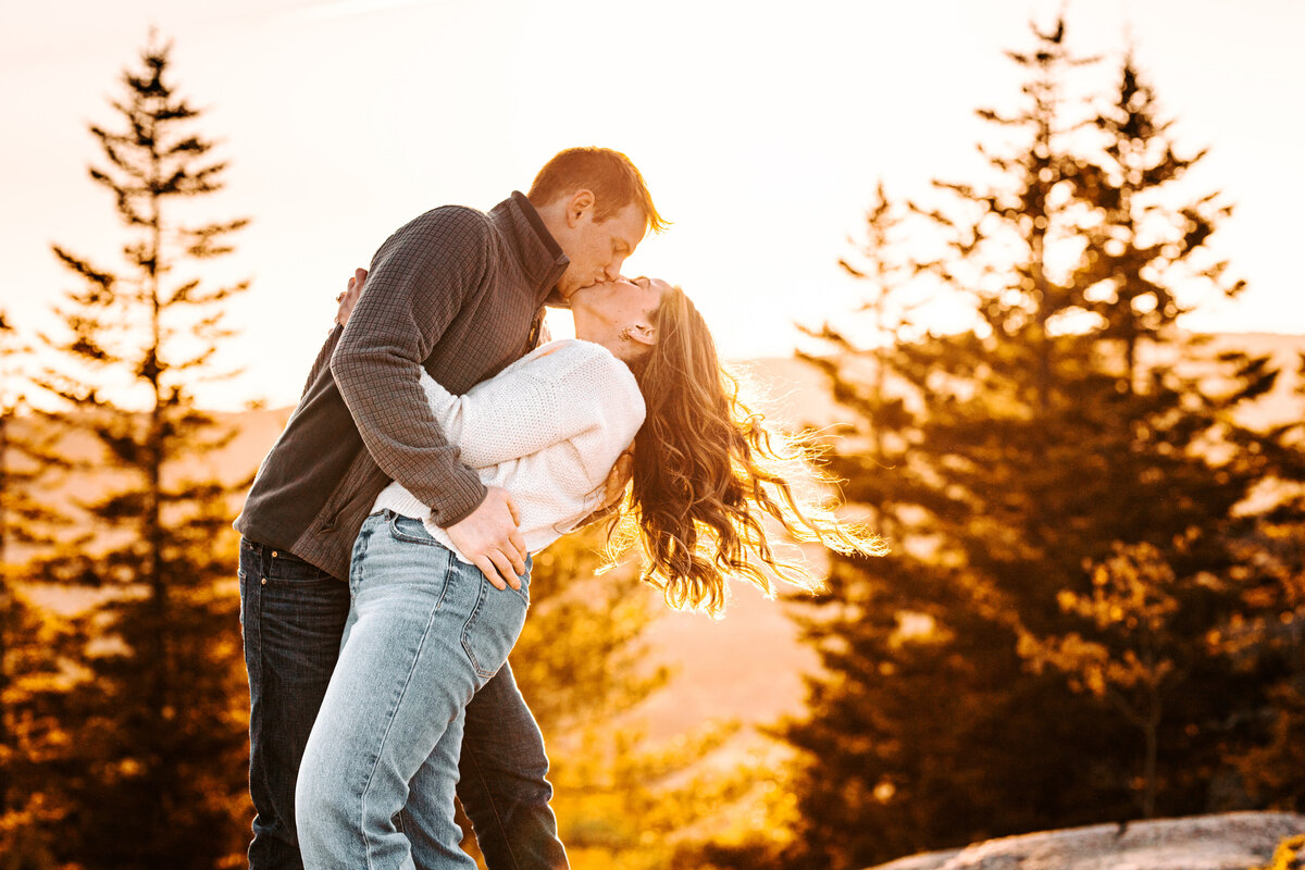 Acadia National Park sunrise engagement session winter sunrise from afar with vibrant colors behind the pines