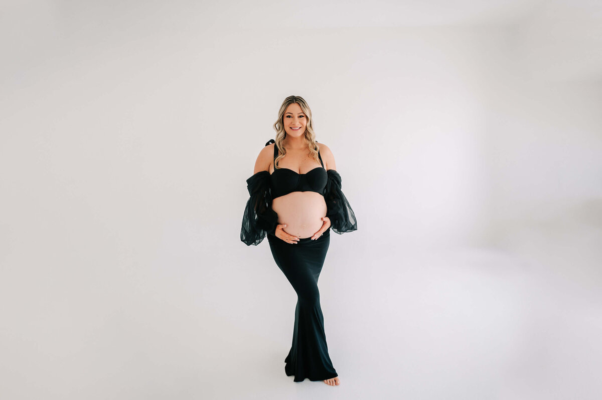 Joplin Mo maternity photography of pregnant mom smiling in black dress