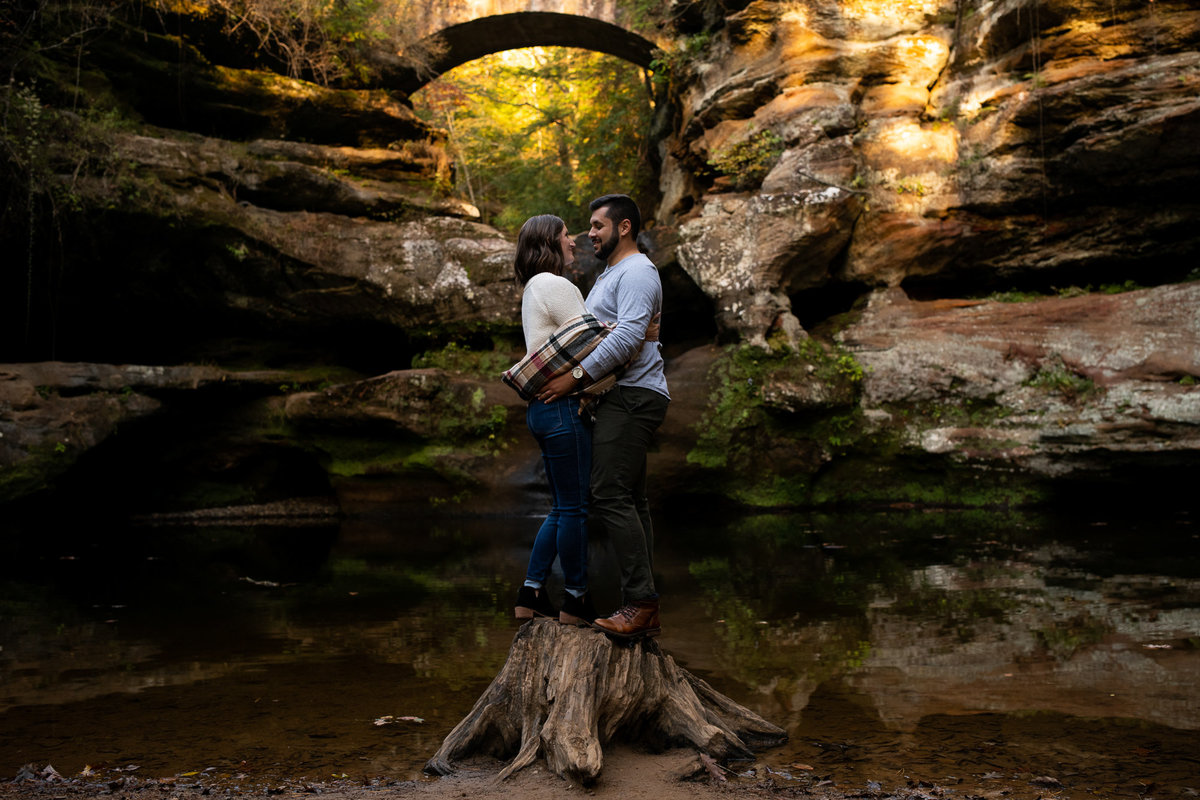 Couple stands on tree stump at Old Man's Cave